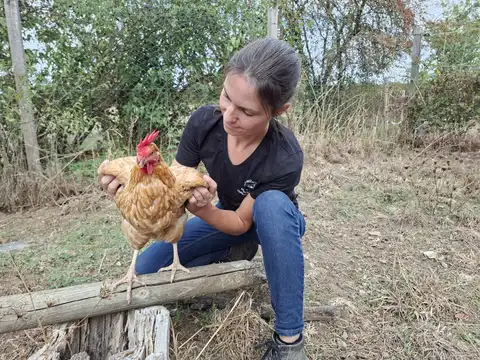 Marine Boullier tenant une poule rousse au creux des mains